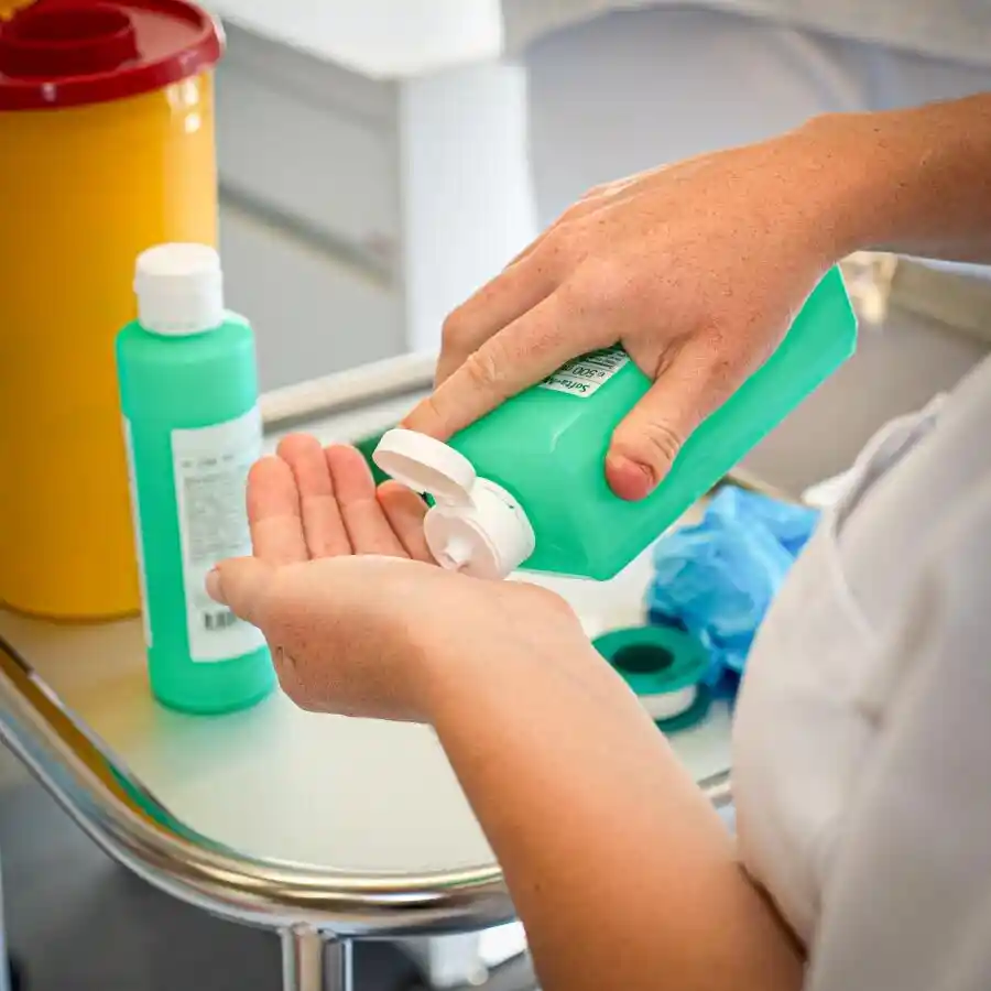 Eine Frau giesst sich Desinfektionsmittel in die Hand